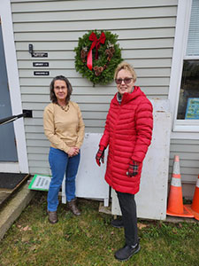 Wreath hanging outside the town office with garden club member and town employee