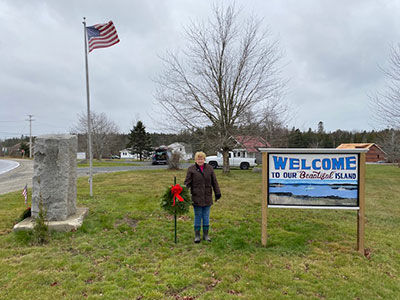 Holiday wreath being added to the Welcome Center area on Little Deer Isle