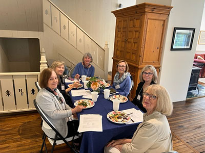 Group of women seated at a table about to eat