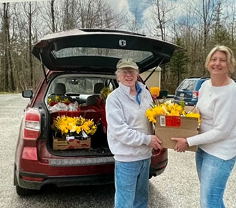 Daffodil arrangements being loaded in a car to be delivered along with Simmering Pot soup