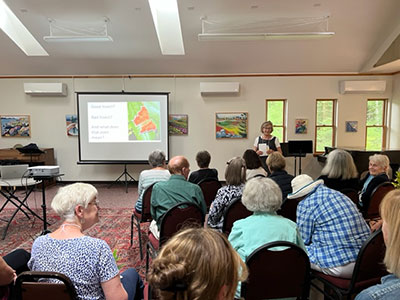 Group of people seated in a room and looking at a presentation